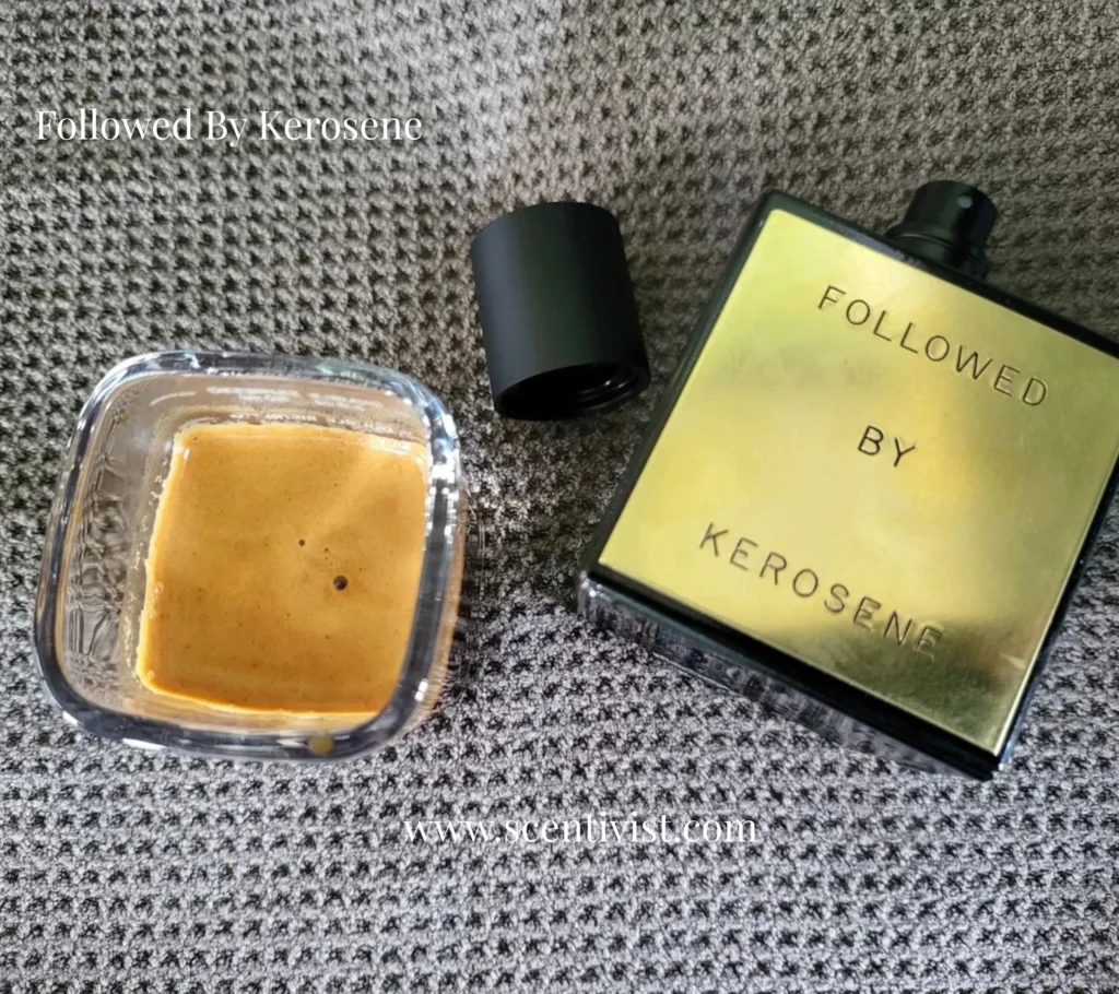 Followed by Kerosene perfume bottle with golden packaging placed beside an open container on textured fabric background.