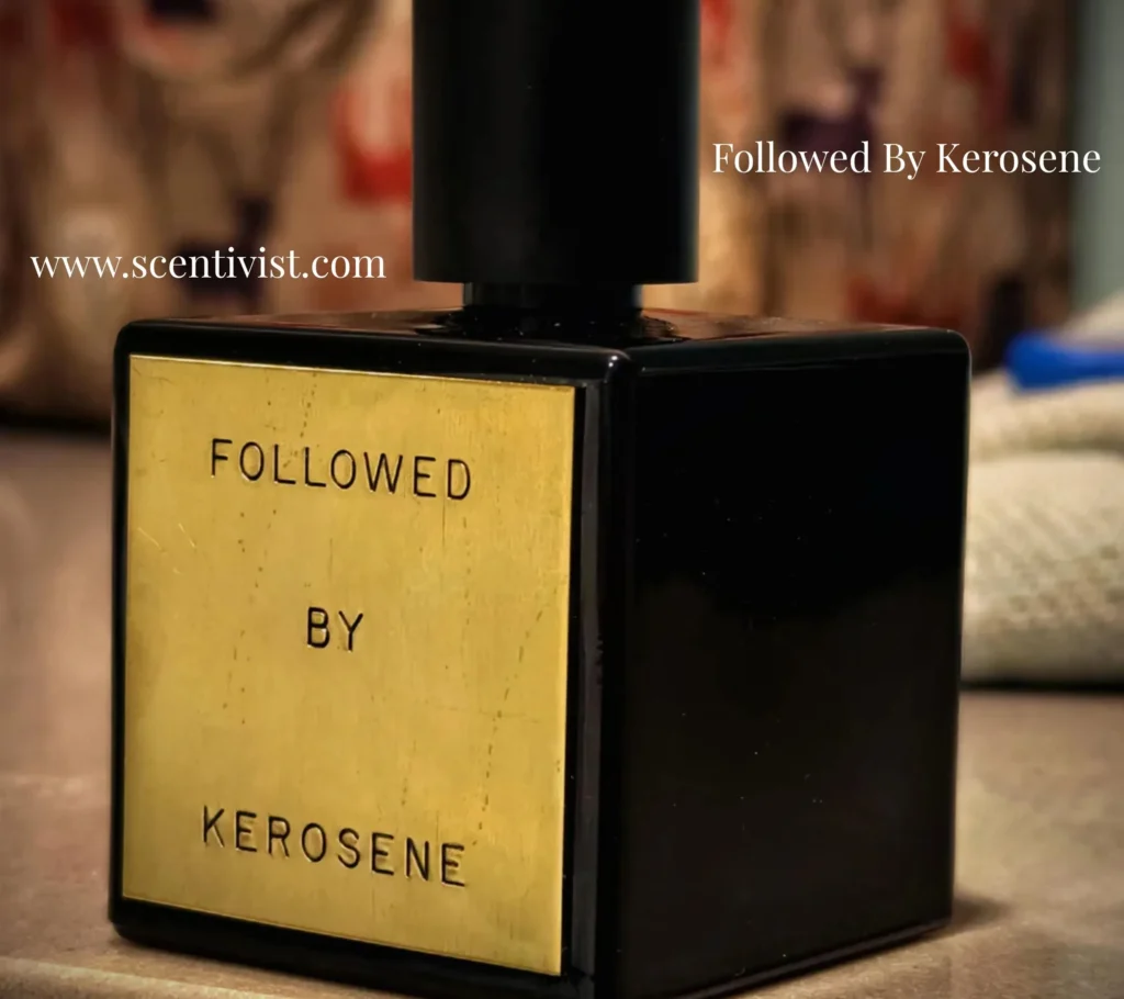 Close-up of Followed by Kerosene perfume bottle with gold label and black cap on a soft background.