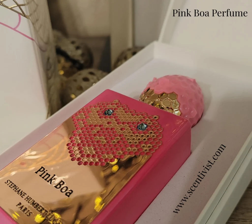 Pink Boa perfume bottle with jeweled snake design and gold cap placed inside a white gift box