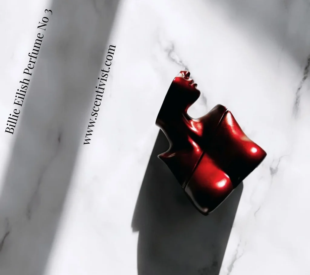Eilish No. 3 Eau de Parfum by Billie Eilish red sculpted perfume bottle placed on a white marble surface.