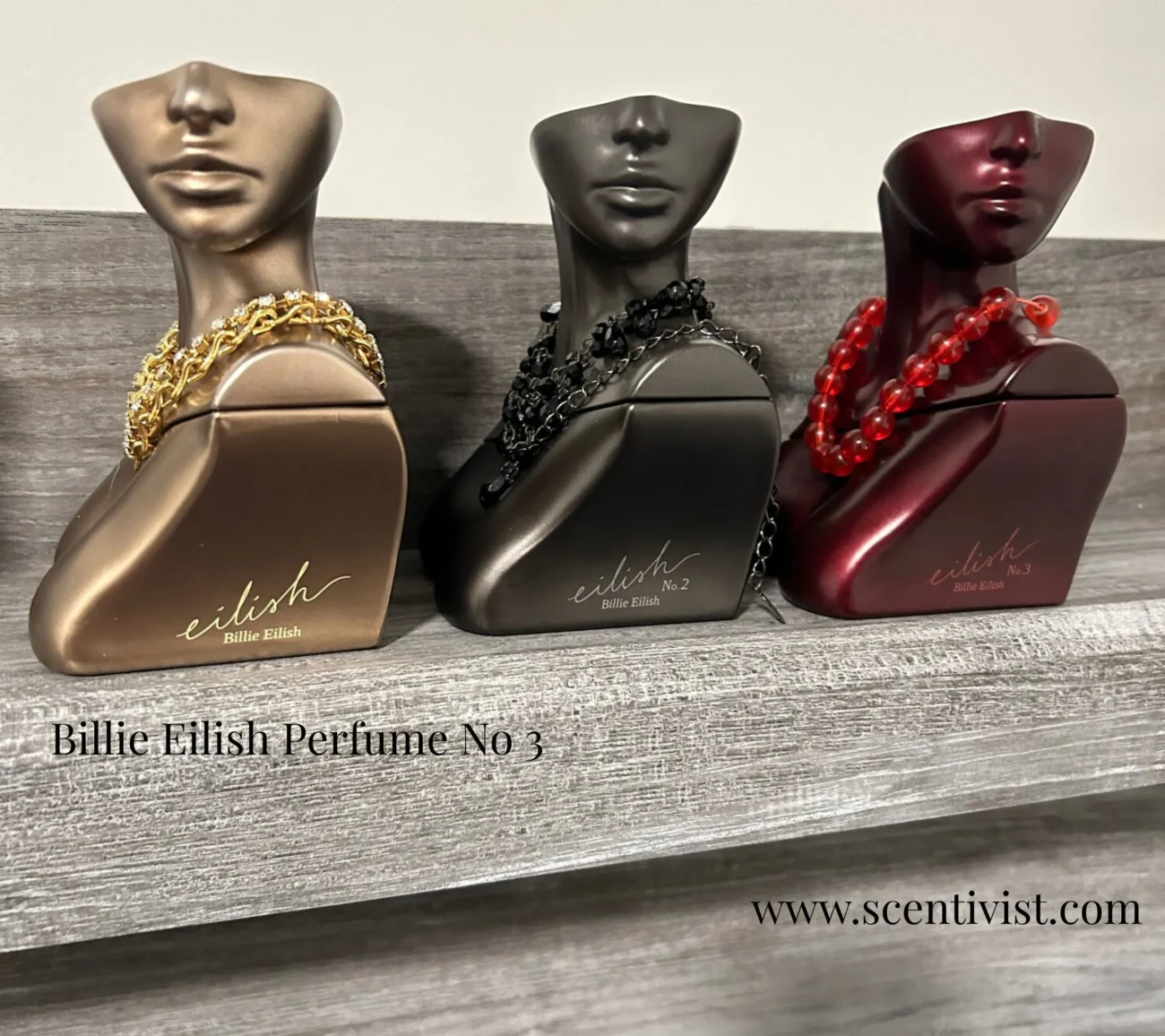 Billie Eilish Perfume No 3 displayed beside Eilish and Eilish No. 2 bottles on a wooden shelf.