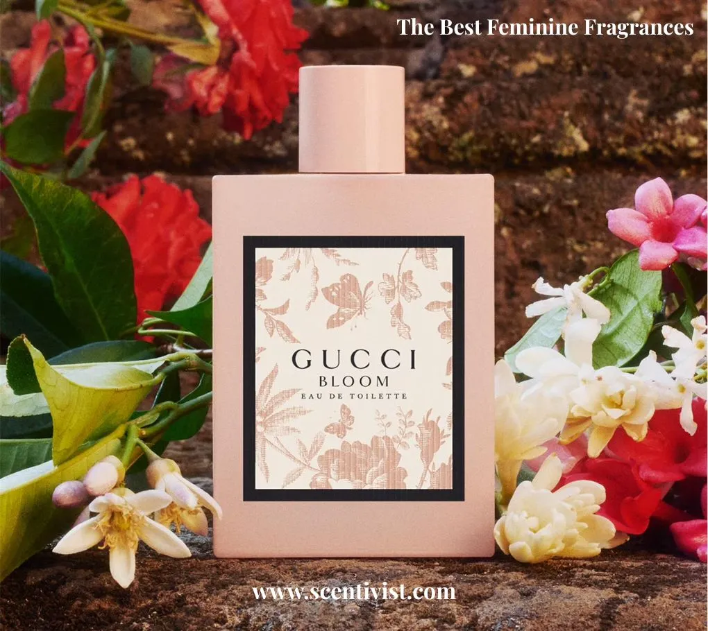 The best feminine fragrances; Gucci Bloom perfume bottle surrounded by vibrant flowers and greenery, set against a natural earthy background.