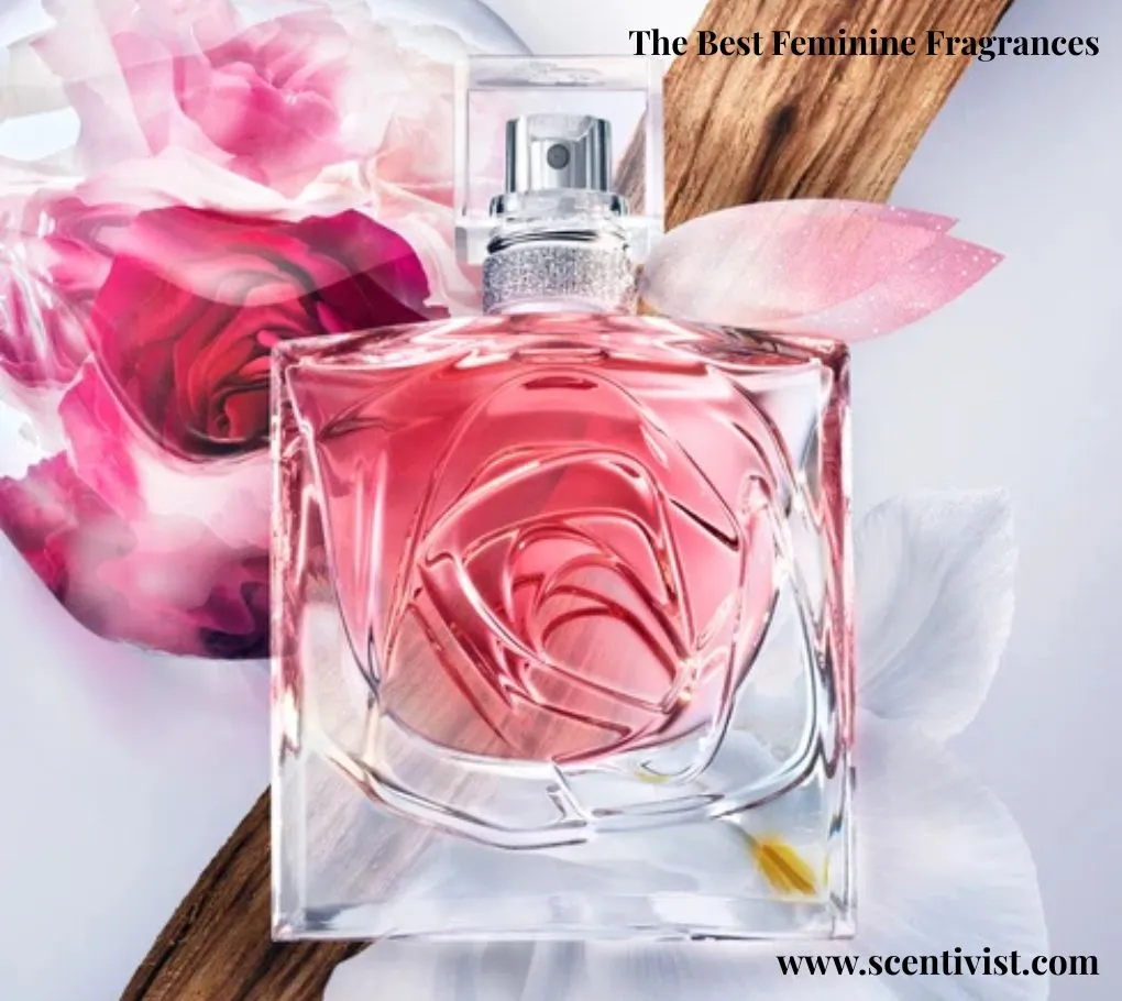 The best feminine fragrances; Lancôme La Vie Est Belle perfume bottle in soft pink tones, surrounded by delicate rose petals and natural wooden elements on a light background.