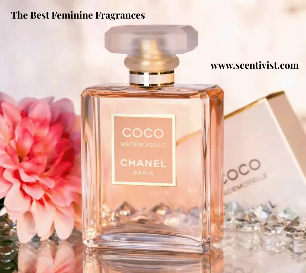 The best feminine fragrance; Chanel Coco Mademoiselle perfume bottle with soft pink liquid, styled with a blooming flower and sparkling crystals on a glossy surface.
