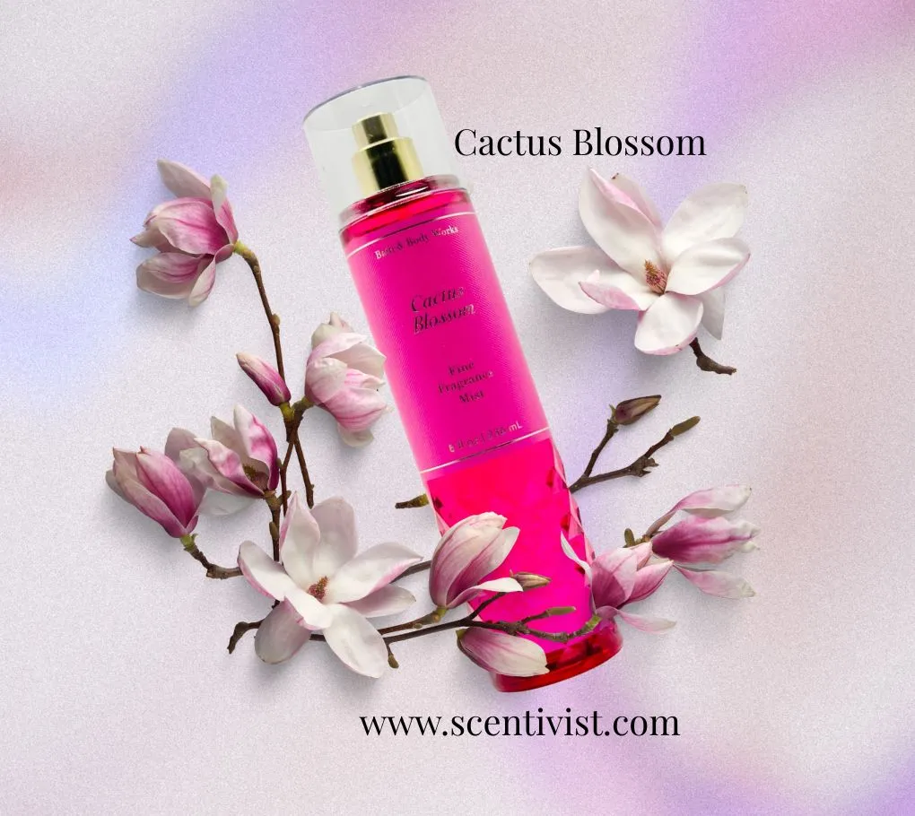 Cactus Blossom fine fragrance mist in a bright pink bottle surrounded by soft white and pink flowers on a light background.