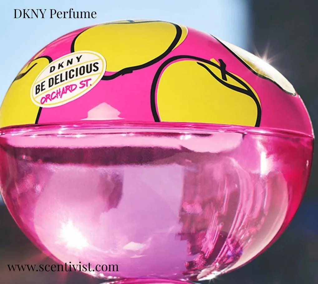DKNY Be Delicious Orchard St. perfume bottle in a bright pink apple-shaped design with yellow graphic accents.