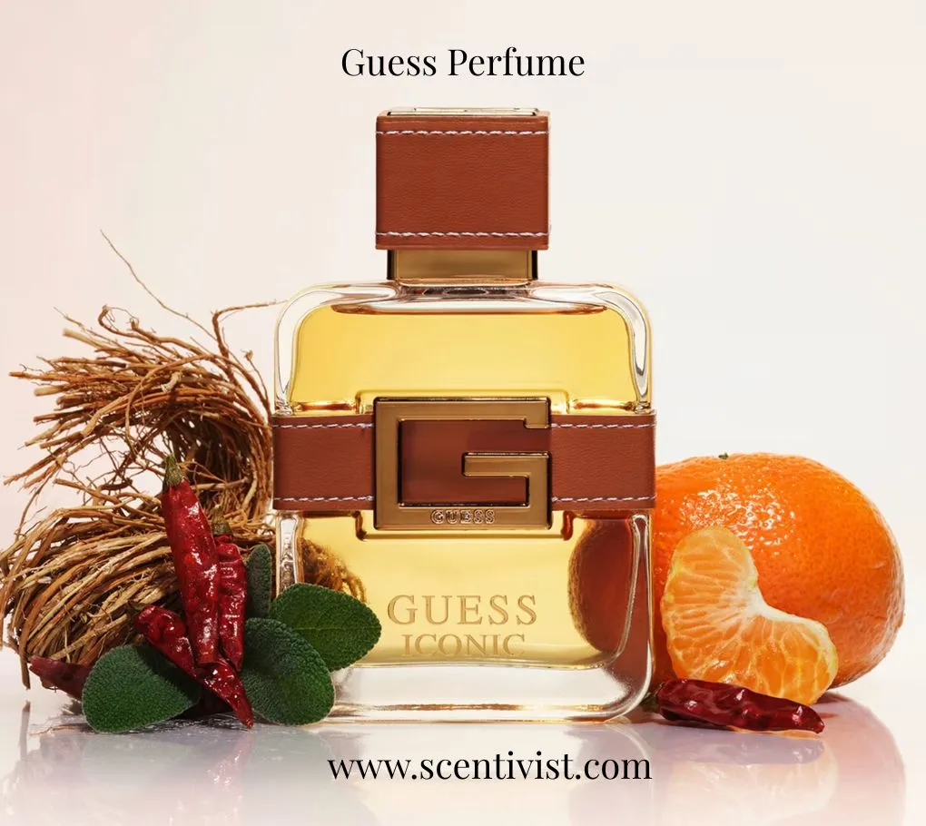 Guess Perfume Iconic  bottle with a warm amber tone, surrounded by chili peppers, herbs, roots, and a fresh mandarin.