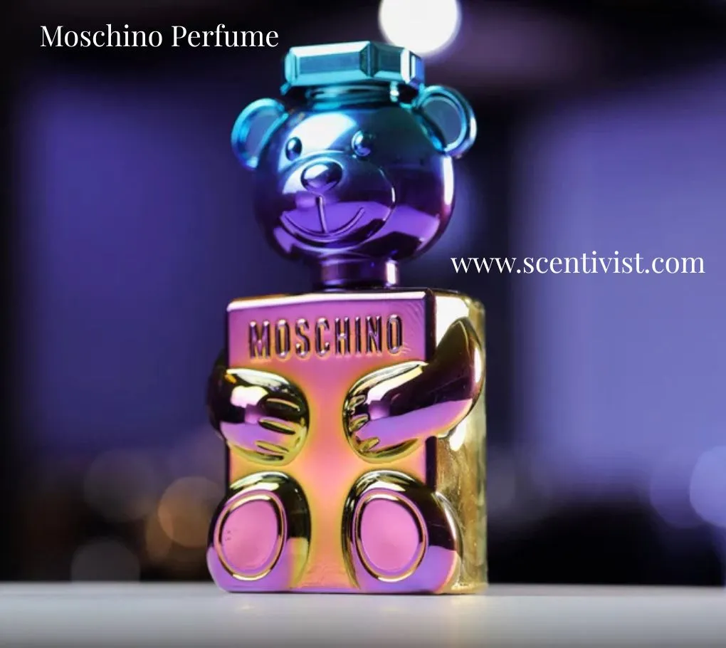 Moschino Toy Boy perfume bottle shaped like a metallic teddy bear with iridescent colors on a blurred night background.