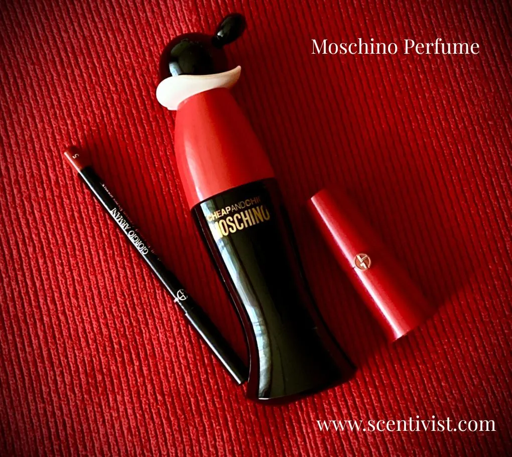 Moschino Cheap & Chic perfume bottle with a playful red and black design placed on a textured red surface.