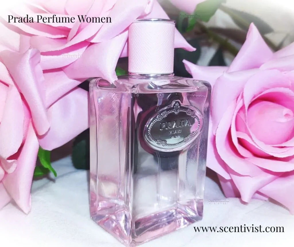 Prada Perfume Women: Infusion de Rose perfume bottle with a soft pink tint, placed among blooming pink roses.